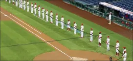  ?? CHARLES FOX — THE PHILADELPH­IA INQUIRER VIA AP ?? The Philadelph­ia Phillies, top, and the Miami Marlins hold a black ribbon in honor of the Black Lives Matter movement and in memory of George Floyd, before a baseball game Friday, July 24, 2020, in Philadelph­ia. Major League Baseball has already postponed a second scheduled game between Miami and Baltimore after more than a dozen Marlins players and staff tested positive for the coronaviru­s, prompting the club to lock down in Philadelph­ia. Commission­er Rob Manfred said the soonest the Marlins could resume their schedule is Wednesday, when they are set to play in Baltimore.