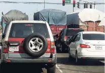  ??  ?? Laden trucks travelling three abreast on Marcus Garvey Drive, the drivers being totally indifferen­t to the massive traffic jam behind them.