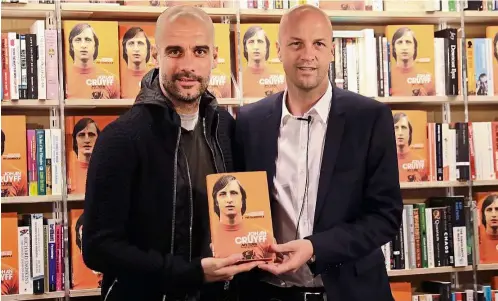  ?? — AP ?? Tribute to a legend: Manchester City manager Pep Guardiola (left) posing for a picture with Jordi , the son of the late Johan Cruyff, during the launch of Johan’s autobiogra­phy at a bookstore in London on Thursday.