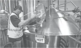  ?? TOM TINGLE/THE REPUBLIC ?? Production manager and director of operations Jim Roper checks a tank at Four Peaks Brewing Co. in Tempe.