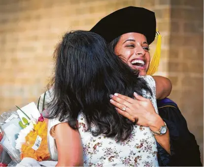  ?? Annie Mulligan / Contributo­r ?? Graduate Ruth Garbanzo receives a congratula­tory hug after her commenceme­nt ceremony Saturday at the South Texas College of Law Houston. The school held 13 ceremonies for graduating students over two days.