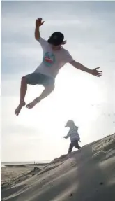  ??  ?? ABOVE Sonny jumping on the beach with Indi TOP The beach hut community at Mudeford