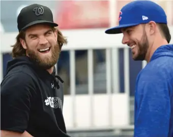  ??  ?? The Nationals’ Bryce Harper, wearing a # VegasStron­g shirt, shares a moment with childhood friend Kris Bryant at Nationals Park in Washington on Thursday. Game 1 of the NLDS is Friday.
| NICK WASS/ AP