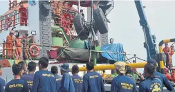  ?? ADEK BERRY AGENCE FRANCÉ PRESSE/GETTY IMAGES ?? The Indonesian navy and members of a search and rescue team lift the wheels of the Lion Air flight JT610 after they were recovered from the Java Sea on Friday.