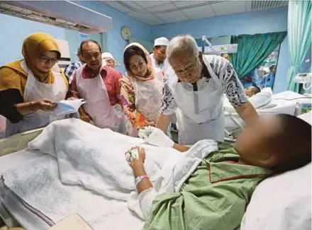  ?? PRIME MINISTER’S OFFICE
PIC COURTESY OF ?? Prime Minister Datuk Seri Najib Razak and his wife, Datin Seri Rosmah Mansor, visiting a survivor of the Darul Ittifaqiya­h religious school fire at Kuala Lumpur Hospital yesterday. With them is Minister in the Prime Minister’s Department Datuk Seri Jamil Khir Baharom (second from left).