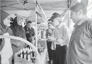  ?? — Gambar Bernama ?? TINJAU: Ahmad (dua, kanan) ketika lawatan pada pelancaran Jualan Jimat Belanja Aidiladha Ambang Merdeka @ Agro Bazaar Kedai Rakyat (AKR) Penaga semalam.