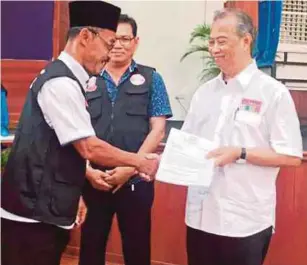  ?? [FOTO MOHD FARID NOH/BH] ?? Muhyiddin menyampaik­an sijil tauliah kepada pegawai lantikan khas kepada beberapa ketua masyarakat pada majlis ramah mesra di Dewan Serbaguna Bukit Gambir, Pagoh, semalam.