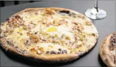  ??  ?? Allora Carbonara pizza with pancetta, cracked pepper, mozzarella, Pecorino Romano, and a farm egg.