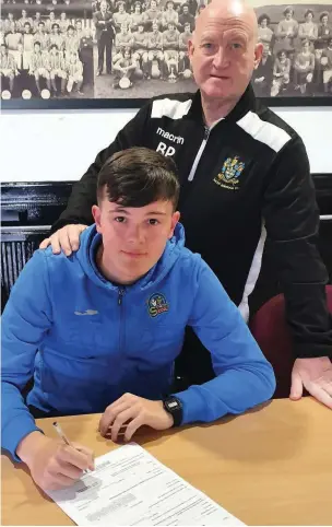  ??  ?? ●● Kyle Brooks, with Bacup manager Brent Peters, signing his contract