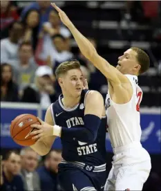  ?? AP Photo/Isaac Brekken ?? Utah State’s Sam Merrill looks to pass as San Diego State’s Malachi Flynn defends during the second half of an NCAA college basketball game for the Mountain West Conference men’s tournament championsh­ip on March 7 in Las Vegas.