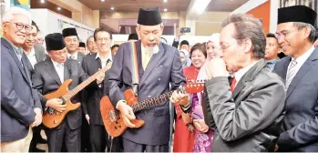  ??  ?? Sabah Yang Dipertua Negeri Tun Juhar Mahiruddin (centre) and Chief Minister Datuk Seri Mohd Shafie Apdal showing their talent in playing the guitar when visiting the Sabah Music Gallery after officiatin­g the exhibition at the Sabah Museum yesterday.