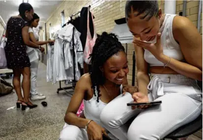  ?? ?? Senior Alicia Rose, 18, performed a ballet solo during the Burke’s Fine Arts Showcase. Before her dance, she watched a recording of a previous performanc­e with junior Melissa Dias,16, (right).