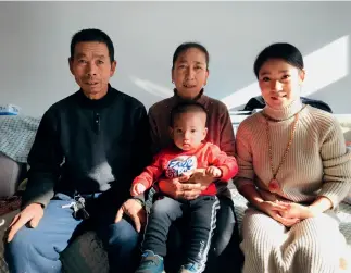  ??  ?? Local villager Gao Junsheng with his family in Shangwopu New Village.