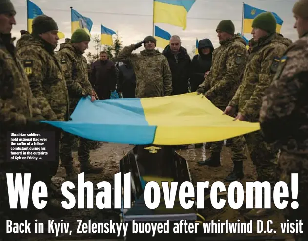  ?? AP ?? Ukrainian soldiers hold national flag over the coffin of a fellow combatant during his funeral in the outskirts of Kyiv on Friday.