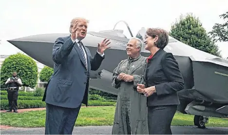  ??  ?? El presidente Trump habla con la presidenta y CEO de Lockheed Martin Marillyn Hewson (d) y un piloto, frente a un avión de combate F-35 que fue parte de los productos “Hechos en EEUU”, mostrados ayer en el jardín de la Casa Blanca./EFE.