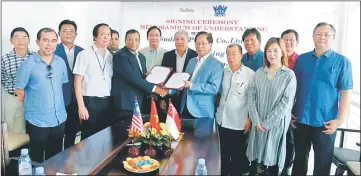  ??  ?? Temenggong Datuk Vincent Lau (front, third right) from KTS Timber Processing Sdn Bhd exchanges documents with Pranod Kr Dalmia from Sudima Panels. Awang Tengah is on Lau’s right.