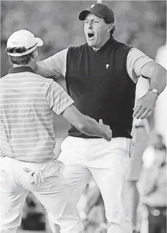  ?? BILL STREICHER, USA TODAY SPORTS ?? Phil Mickelson and Kevin Kisner celebrate after Mickelson made a putt on the 18th hole during the second round four-ball matches of The Presidents Cup.