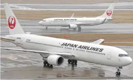  ??  ?? TOKYO: Japan Airlines passenger planes on the runway at Haneda airport in Tokyo on January 29, 2016. The carrier said yesterday its bottom line in the six months through September shrank to $682 million, down more than 30 percent from a year ago, with...