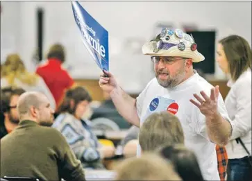  ?? Dave Kettering Telegraph Herald ?? OBSERVER DAVID SOLL of Rockford, Ill., talks to participan­ts during a Democratic caucus in Dubuque, Iowa. The system didn’t begin to break down until precinct chairs tried to report their results.