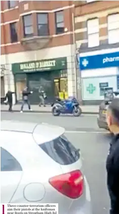  ??  ?? 1
Three counter-terrorism officers aim their pistols at the knifeman near Boots on Streatham High Rd