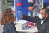  ?? (AFP) ?? A medical worker takes a nasal swab sample from a student to test for COVID-19 at the Brooklyn Health Medical Alliance on October 8