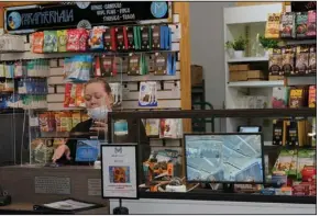  ?? (AP/Ted S. Warren) ?? Laurie Volpe, the medical coordinato­r at Mary Mart, a marijuana store in Tacoma, Wash., rings up a sale earlier this month next to a security camera screen.