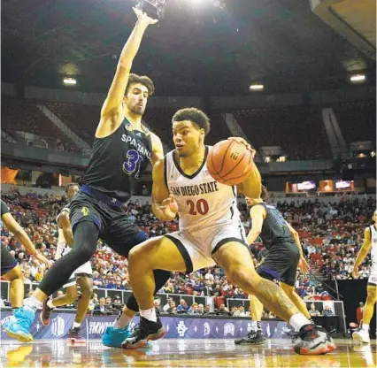  ?? K.C. ALFRED U-T ?? Aztecs’ Matt Bradley, who had eight points, drives in against Spartans’ Tibet Gorener during the conference semifinals.