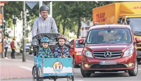  ?? RP-FOTO: HANS-JÜRGEN BAUER ?? Mit dem Transportf­ahrrad bringt Frank Schubert seine Jungs Jakob (l.) und Mats in die Kindertage­sstätte. Die Kreuzung Alt-Eller / Weinheimer Straße findet er gefährlich.