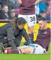  ??  ?? Hearts’ Michael Smith receives treatment.