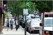  ?? NWA Democrat-Gazette/ANDY SHUPE ?? Pedestrian­s walk at midday Tuesday along Dickson Street in Fayettevil­le. Dickson Street Merchants Associatio­n released a survey concerning parking in downtown they compiled by polling 1,149 people during a two-week period in April.