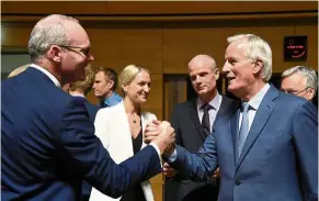  ?? — AFP ?? Warm greetings: Coveney (left) shaking hands with Barnier during a meeting in Luxembourg.