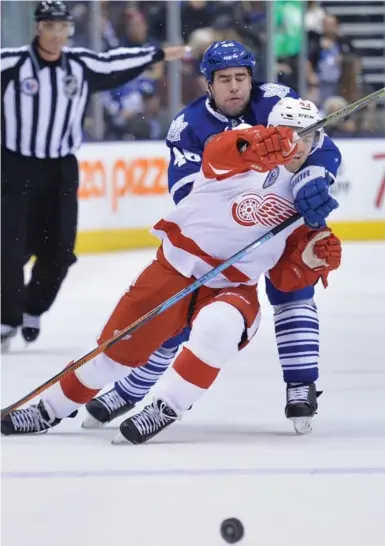  ?? NATHAN DENETTE/THE CANADIAN PRESS ?? Leafs defenceman Roman Polack trips up Detroit forward Darren Helm. Toronto limited the Wings to 24 shots.