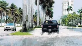  ?? TAIMY ALVAREZ/SOUTH FLORIDA SUN SENTINEL ?? Cars slowly maneuver parts of Las Olas Boulevard flooded by king tides, flooding in lowlying areas, Tuesday afternoon in Fort Lauderdale.