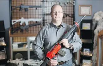  ?? Adrian Shellard/For Postmedia News ?? James Cox, owner of The Shooting Edge in Calgary, holds a Swiss Arms sporting rifle that the RCMP could reclassify as prohibited. A review has dragged on for months, frustratin­g gun enthusiast­s.