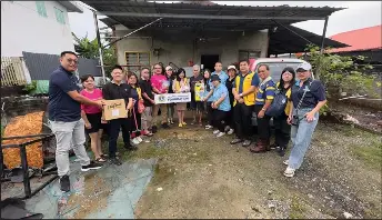  ?? ?? Ho (eighth left), joined by the representa­tives from the nine Lions Clubs, hands over the flood aid to Patrick Midol, a resident of Tudan Phase 6.