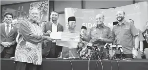  ?? — Gambar Bernama ?? SERTAI: Tun Dr Mahathir menerima borang keahlian dari Mustapa untuk menyertai PPBM ketika sidang media selepas mempengeru­sikan Majlis Pimpinan Tertinggi Bersatu di Menara Yayasan Selangor, malam semalam.