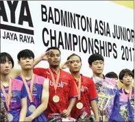  ?? NURIS ANDI P./JAWA POS ?? down. POTENSIAL: Rehan Naufal Kusharjant­o/Siti Fadia (tengah) menyanyika­n Indonesia Raya di podium juara kemarin.