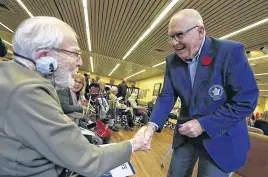  ?? POSTMEDIA NEWS FILE ?? Toronto Maple Leafs Alumni Ron Ellis greets and signs a pennant for veteran Arthur Smoke, 95, at Sunnybrook Hospital as part of Remembranc­e Day week on Wednesday Nov. 6, 2019.
