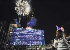  ?? Sebastian Scheiner The Associated Press ?? Israelis watch a fireworks show Wednesday in Tel Aviv during the country’s Independen­ce Day celebratio­ns after more than a year of coronaviru­s restrictio­ns.