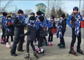  ?? ?? Members of the Mount Clemens Figure Skating Club try to stay warm while they wait for the parade to begin.