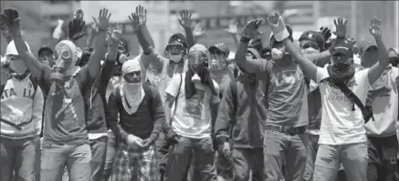  ?? ARIANA CUBILLOS, THE ASSOCIATED PRESS ?? Opponents of President Nicolas Maduro challenge security forces blocking them from marching to the ombudsman’s office in downtown Caracas, Venezuela on Wednesday.