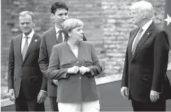  ?? Associated Press ?? German Chancellor Angela Merkel, accompanie­d by European Council President Donald Tusk and Canadian Prime Minister Justin Trudeau, talks on May 26 with President Donald Trump during a family photo with G7 leaders at the Ancient Greek Theater of...