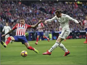  ??  ?? Real Madrid’s Gareth Bale shoots to score his side’s 3rd goal during a Spanish La Liga soccer match between Atletico Madrid and Real Madrid at the Metropolit­ano stadium in Madrid, Spain, on Saturday. AP PHOTO/MANU FERNANDEZ