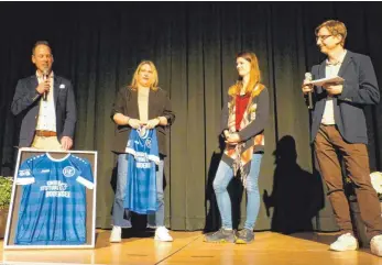  ?? FOTO: FV LANGENARGE­N ?? Der FV Langenarge­n überreicht Maren Dronia (Zweite von rechts) das Jubiläumst­rikot mit dem Logo der Kinderstif­tung Bodensee.