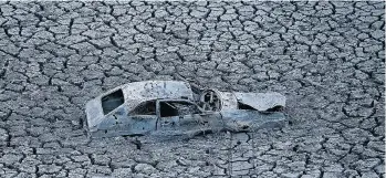  ?? JUSTIN SULLIVAN/GETTY IMAGES ?? A car sits in dried and cracked earth of what was the bottom of the Almaden Reservoir last year in San Jose. California is now facing its fourth straight year of drought conditions.