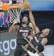  ?? Ashley Landis Associated Press ?? BAM ADEBAYO shoots as teammate Jimmy Butler watches. Adebayo had 14 points and 19 rebounds.