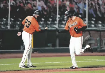  ?? ASSOCIATED PRESS ?? SAN FRANCISCO GIANTS’ WILMER FLORES (right) is congratula­ted by third base coach Ron Wotus as he rounds the bases after hitting a two-run home run off Arizona Diamondbac­ks starting pitcher Robbie Ray during the fifth inning of Friday’s game in San Francisco.