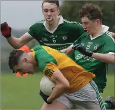  ??  ?? It’s head down from Jason Devereux of Our Lady’s Island/St. Fintan’s as he tries to break free of Shane Roche and Dylan Mooney.