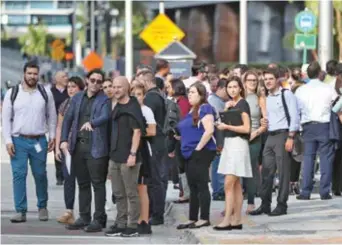  ?? AFP ?? La gente espera afuera después de evacuar los edificios de oficinas después de un terremoto en el sur de Cuba, ayer en Miami, Florida.