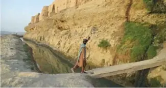  ??  ?? Un homme franchit un pont devant le palais Qal-e-Kohna près de Lashkar Gah, dans la province du Helmand, le 27 mars 2021 en Afghanista­n